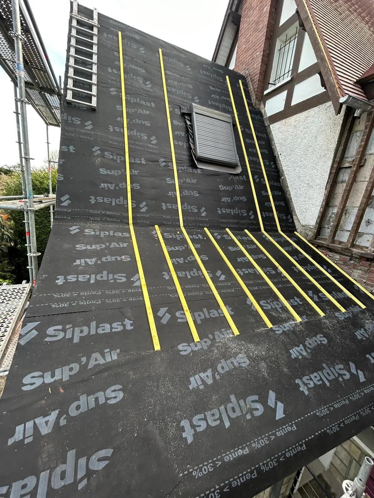 Fenêtre de toit et écran de sous-toiture lors d'un chantier de couverture