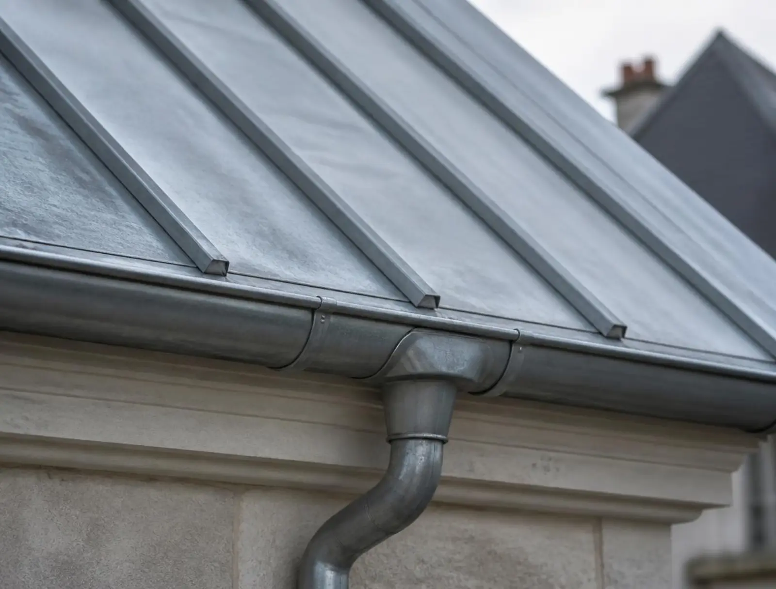 Gouttière et éléments de zinguerie sur une toiture